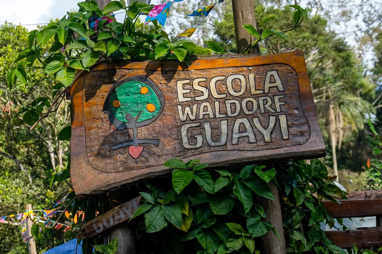 Placa de madeira entalhada com o nome da Escola Waldorf Guayi